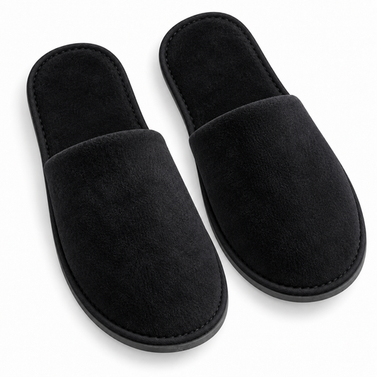 Overhead view of black closed-toe velour hotel slippers