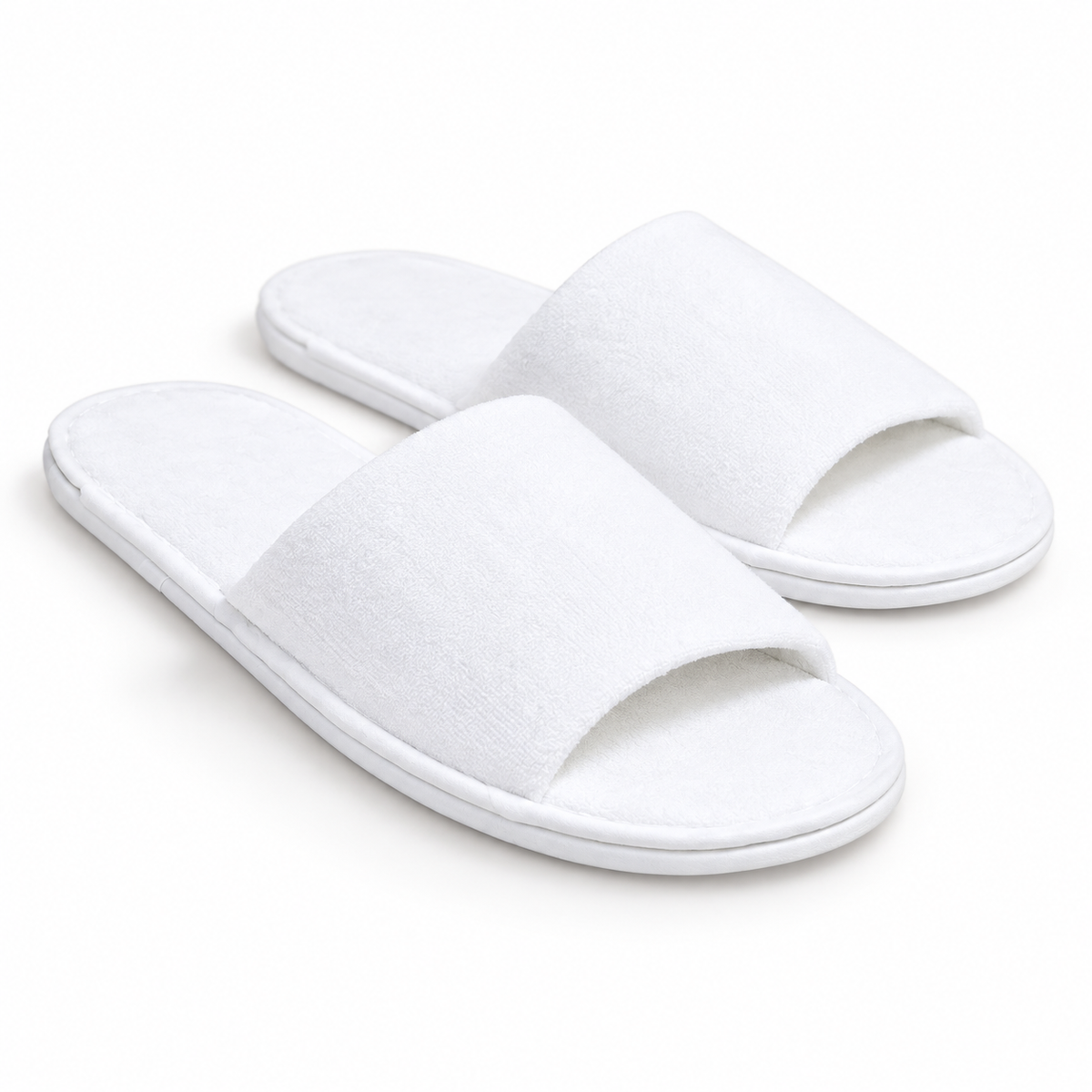 Pair of white open-toe luxury hotel slippers, three-quarter view