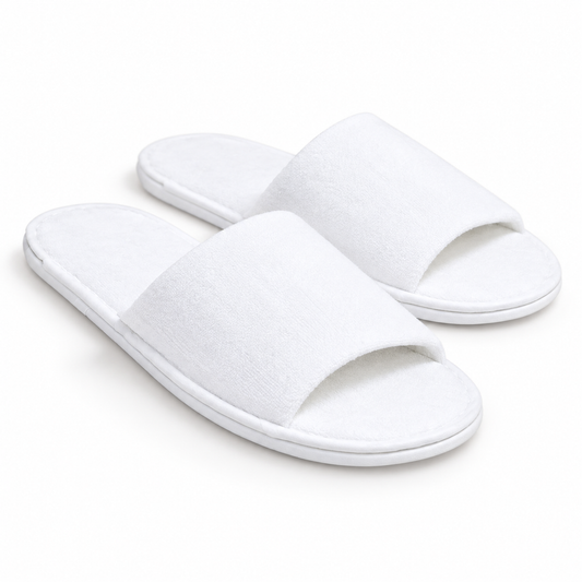 Pair of white open-toe luxury hotel slippers, three-quarter view