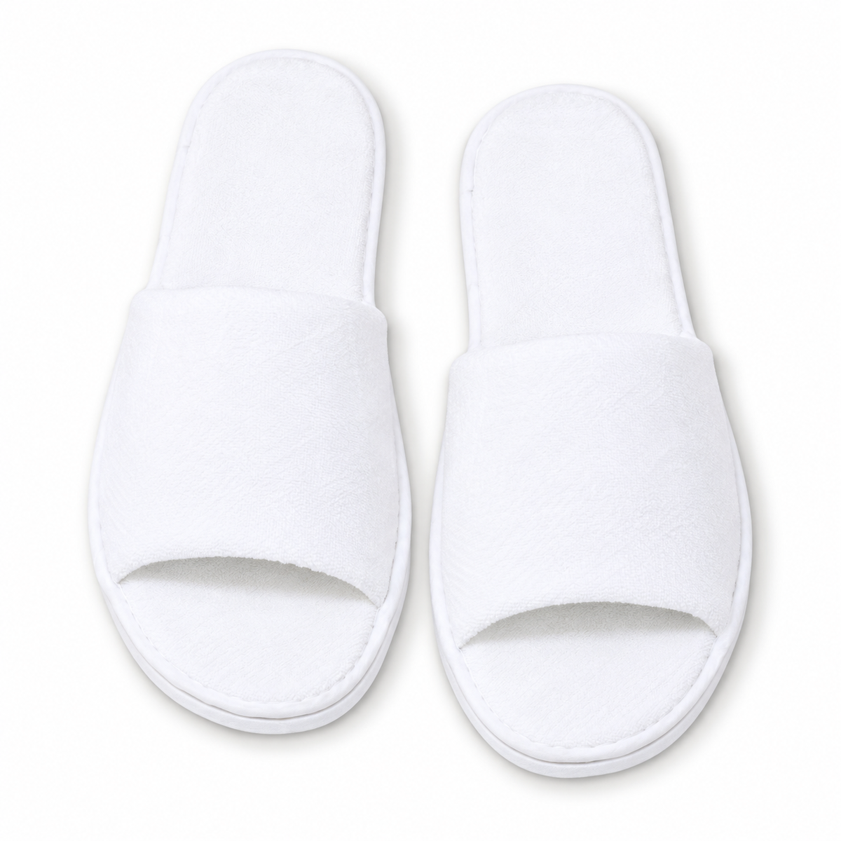Overhead view of white open-toe luxury hotel slippers