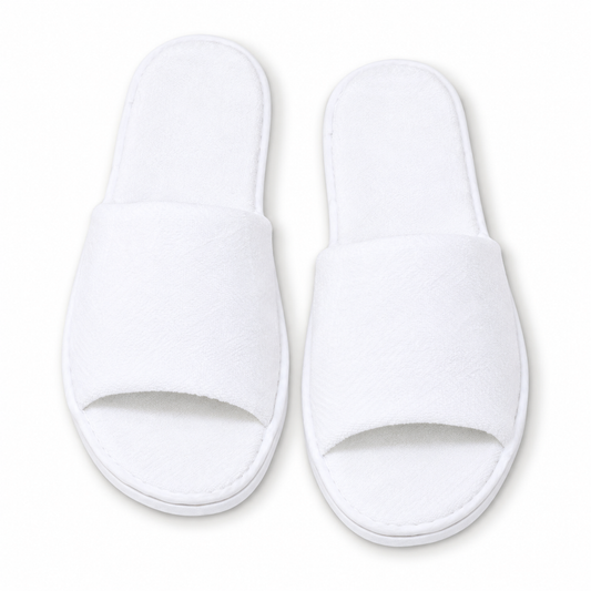 Overhead view of white open-toe luxury hotel slippers